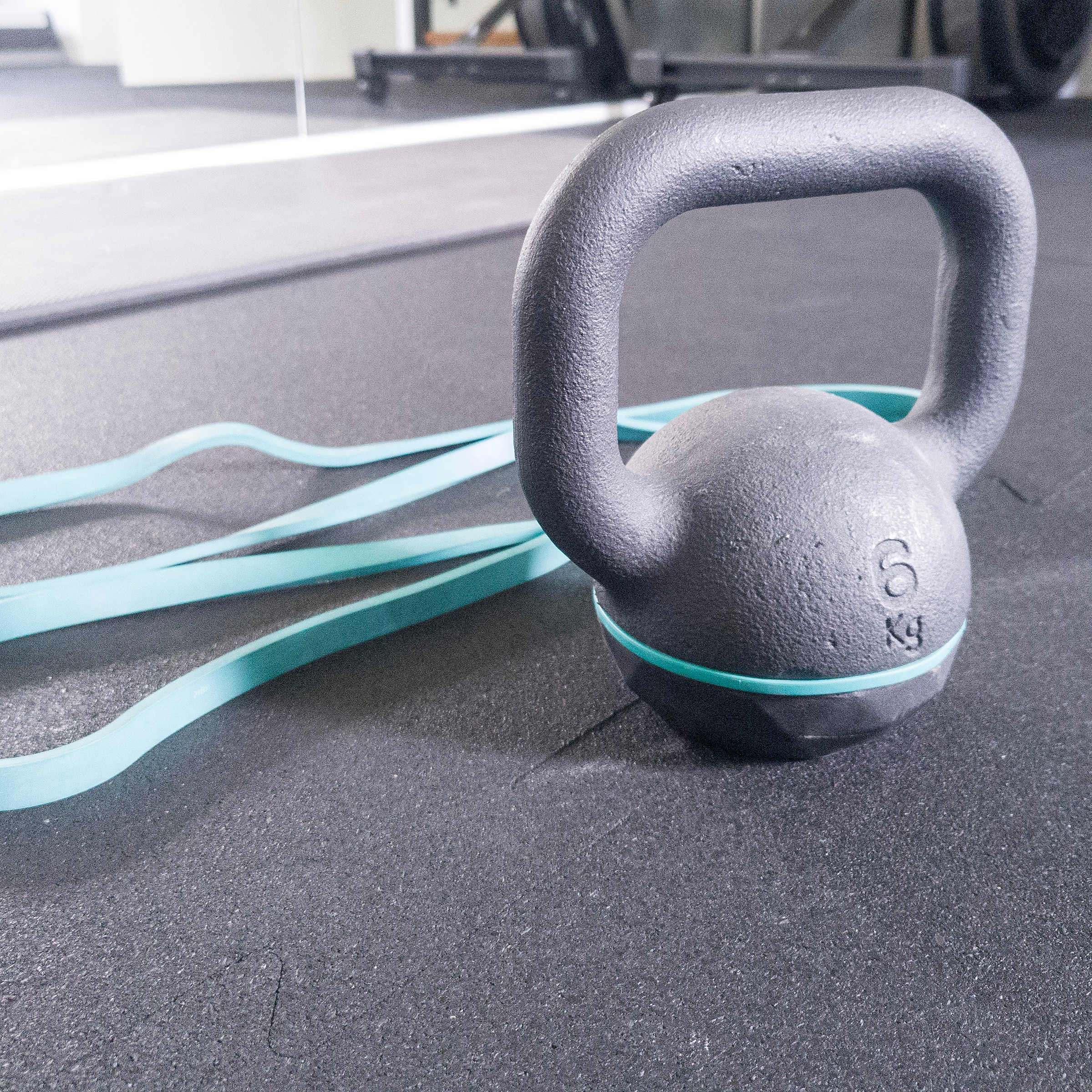 Kettlebell i guma oporowa na macie — sprzęt gotowy do treningu.